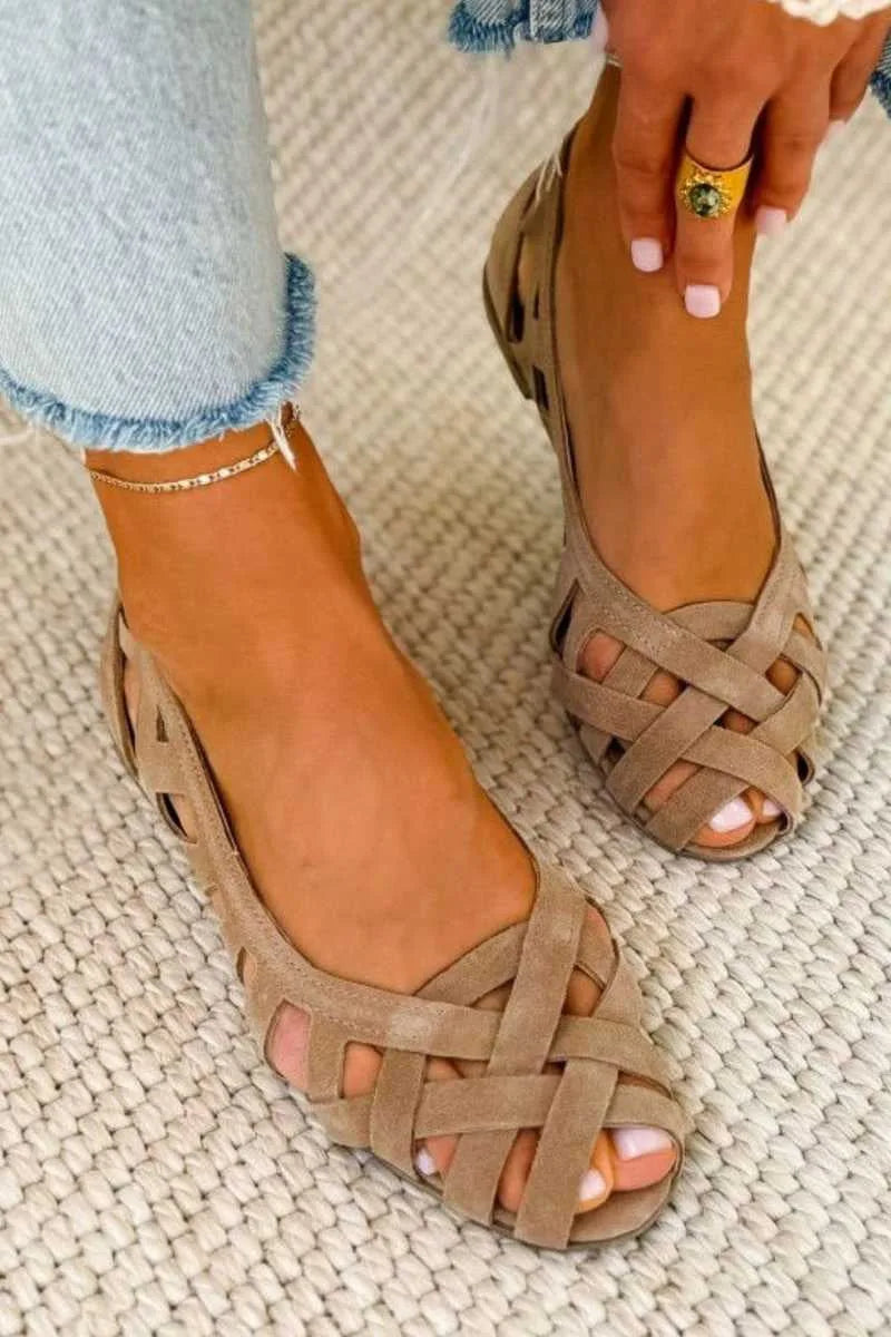Side angle of taupe woven suede sandal flats worn with jeans, gold anklet visible