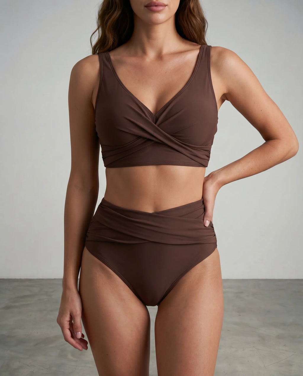 Front view of a woman wearing a brown wrap-style bikini with a twist front top and high-waisted ruched bottoms