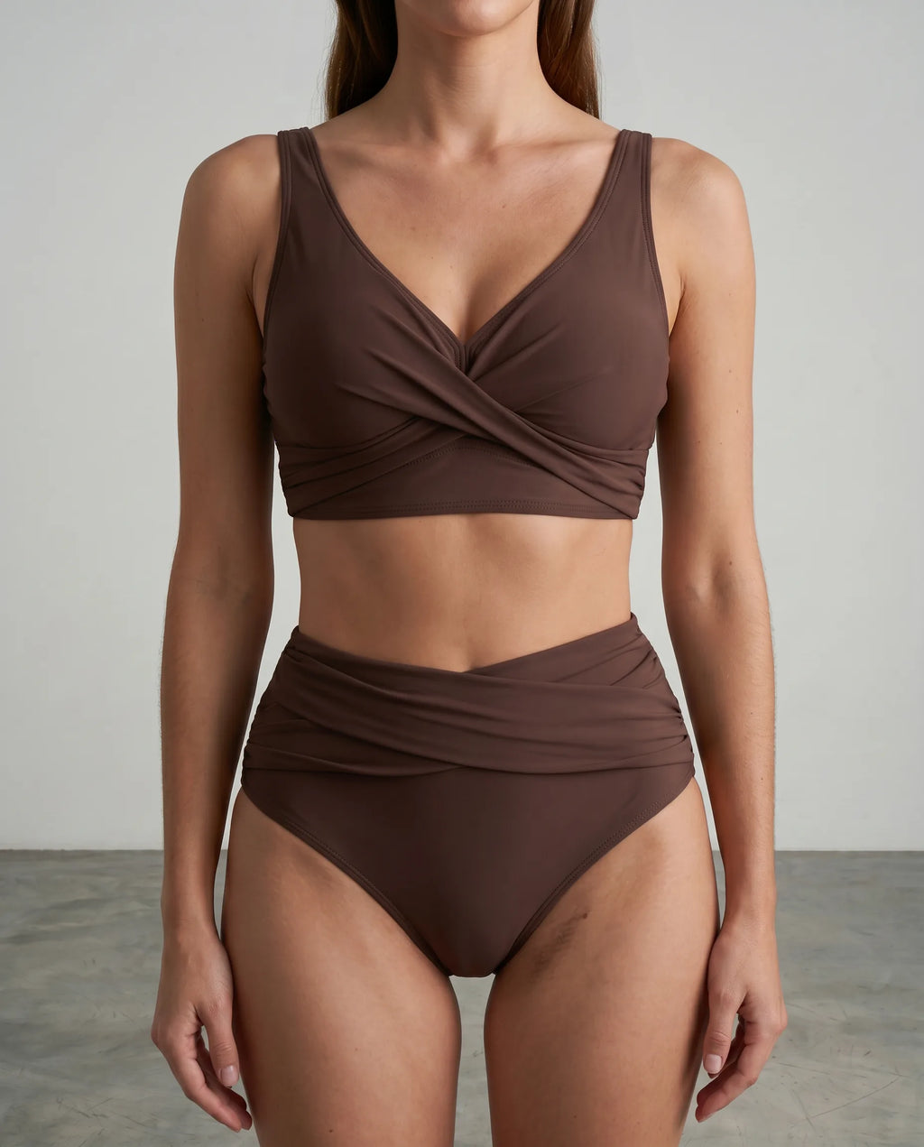 Close-up of a brown wrap bikini top showing the twist front detail and soft stretch fabric texture