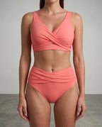 Front view of a coral orange wrap bikini with twist detailing on the top and matching high-waisted bottoms